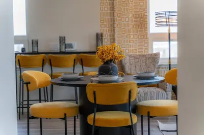 a dining room with a table and yellow chairs at Bright & Bold+NYC View, Sleep 13, Park 2 cars FREE in East Orange