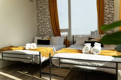 two beds sitting next to each other in a room at Bright & Bold+NYC View, Sleep 13, Park 2 cars FREE in East Orange