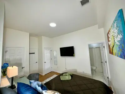 a living room with a bed and a tv on the wall at BP STAYS - Hotel-Style, No Host, Professionally Managed ID255 in Jersey City
