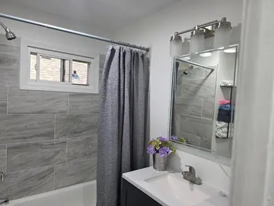 a white bathroom with a sink and a shower at Charming 3 bedroom 2 bath home in Bloomfield with wishing well in Bloomfield