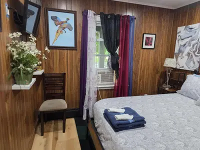 a bedroom with a bed and a chair and a window at Charming 3 bedroom 2 bath home in Bloomfield with wishing well in Bloomfield