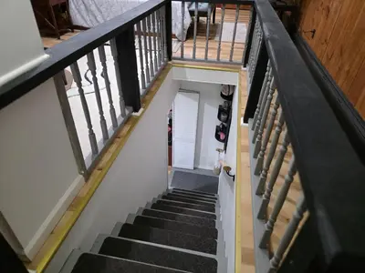 an overhead view of a staircase with black carpeted stairs at Charming 3 bedroom 2 bath home in Bloomfield with wishing well in Bloomfield