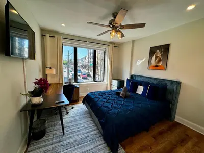 a bedroom with a blue bed and a window at BP STAYS - Hotel-Style, No Host, Professionally Managed ID297 in Jersey City