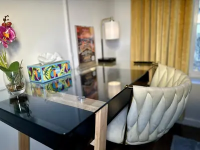a glass desk with a chair and a vase of flowers at BP STAYS - Hotel-Style, No Host, Professionally Managed ID289 in Jersey City