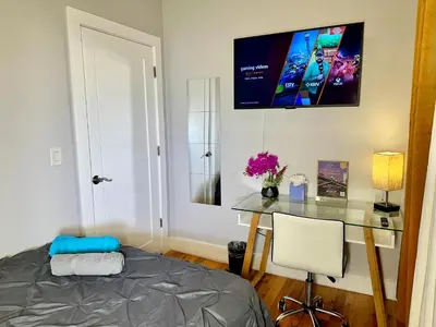 a bedroom with a desk and a table with a chair at BP STAYS - Hotel-Style, No Host, Professionally Managed ID265 in Jersey City
