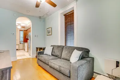 a living room with a couch and a kitchen at Walk to Washington St Hoboken Apt with Balcony! in Hoboken