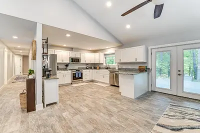 a large kitchen with white cabinets and a ceiling fan at Fish and Swim Home with Catskill Creek Views! in East Durham