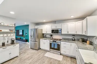 a kitchen with white cabinets and stainless steel appliances at Fish and Swim Home with Catskill Creek Views! in East Durham