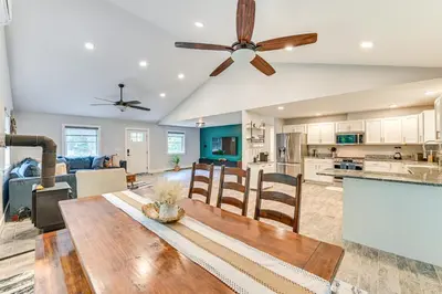 a kitchen and living room with a wooden table and a ceiling fan at Fish and Swim Home with Catskill Creek Views! in East Durham