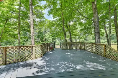 a wooden bridge in a forest with trees at Fish and Swim Home with Catskill Creek Views! in East Durham