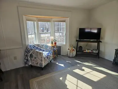 a living room with a chair and a flat screen tv at Charming Countryside Retreat in Fort Plain