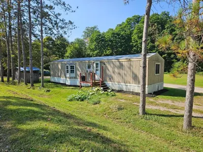 an old trailer in a field with trees at Charming Countryside Retreat in Fort Plain