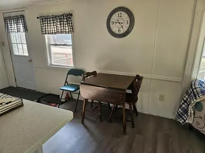 a dining room with a table and a clock on the wall at Charming Countryside Retreat in Fort Plain