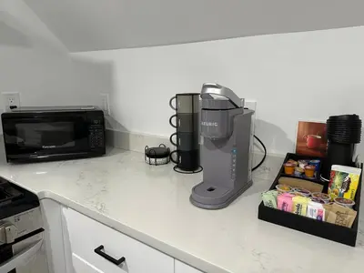 a kitchen counter with a coffee maker and a microwave at NEW Modern NYC Escape near MetLife AmDream MALL EWR in Bergenfield