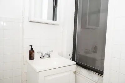 a white bathroom with a sink and a shower at East2 Village Center Apartment7 w Full Amenities Great New York Location in New York