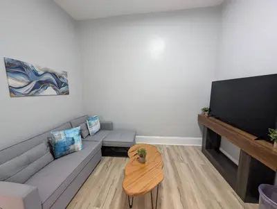 a living room with a couch and a flat screen tv at Central brownstone in Hoboken Dwntn! 15 mins to NY in Hoboken
