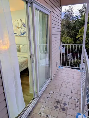 a sliding glass door to a balcony with a bed at Newly Renovated Charming Apt! 30 Mins to Manhattan in Jersey City