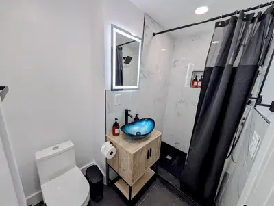 a bathroom with a blue sink and a toilet at Newly Renovated Charming Apt! 30 Mins to Manhattan in Jersey City