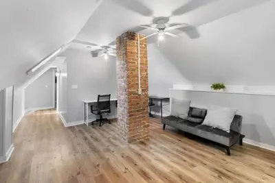 a living room with a couch and a brick pillar at SCSU Two Bedroom Suite in New Haven