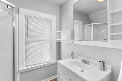 a white bathroom with a sink and a mirror at SCSU Two Bedroom Suite in New Haven