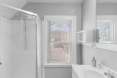 a white bathroom with a shower and a sink at SCSU Two Bedroom Suite in New Haven