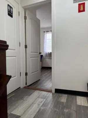 a hallway with white walls and wooden floors and doors at Classic Comfort Room Near LAGUARDIA AIRPORT in North Beach