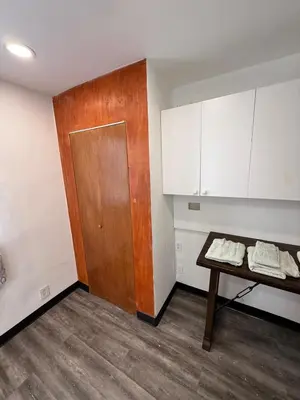 a room with a table and a wooden door at Classic Comfort Room Near LAGUARDIA AIRPORT in North Beach