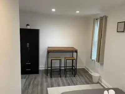 a room with a table and chairs and a black cabinet at Classic Comfort Room Near LAGUARDIA AIRPORT in North Beach