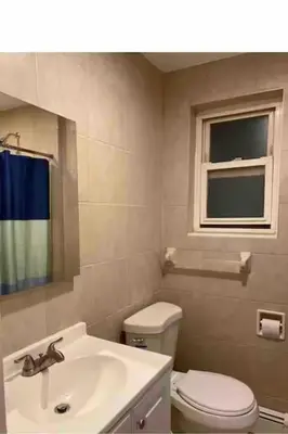 a bathroom with a toilet and a sink and a window at Classic Comfort Room Near LAGUARDIA AIRPORT in North Beach