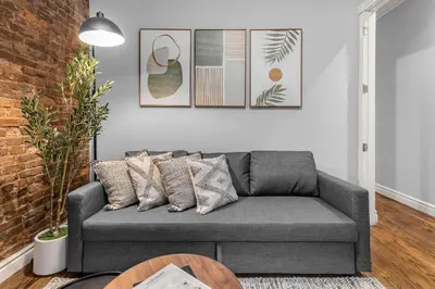 a living room with a gray couch and a table at Bold Manhattan Base in Prime Nolita in New York