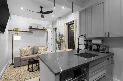 a kitchen with a counter top and a living room at Modern Nolita Hideaway in New York