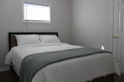 a bed in a white room with a window at Lakefront Haven on Greenwood Lake in West Milford