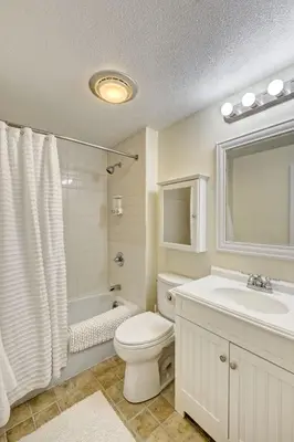 a white bathroom with a toilet and a sink at Cottage in the woods in Salisbury