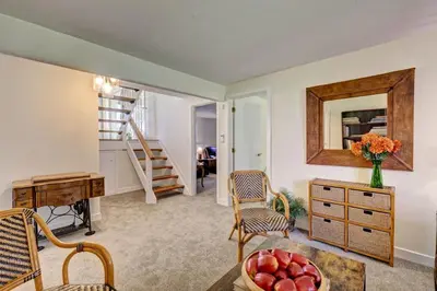 a living room with a desk and a table with a bowl of apples at Cottage in the woods in Salisbury