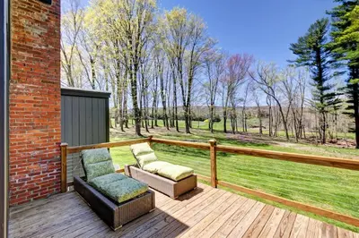 a wooden deck with two chairs and a couch at Cottage in the woods in Salisbury