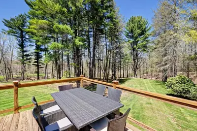 a patio with a table and chairs on a wooden deck at Cottage in the woods in Salisbury