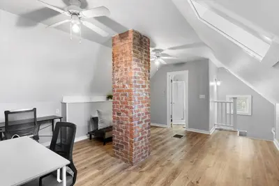 a room with a brick pillar and a table and chairs at Owl's Nest - 5BR apartment in New Haven