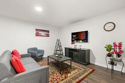 a living room with a gray couch and a fireplace at 7 guests NYC-NWK Free parking in Newark