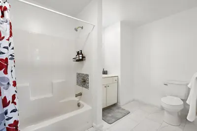 a white bathroom with a toilet and a shower at 7 guests NYC-NWK Free parking in Newark