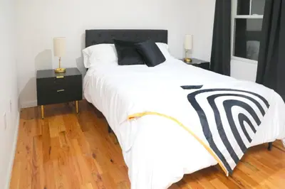 a large bed with a black and white comforter at Modern Minimalist Lux Paradise in Newark