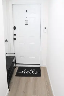 a black welcome mat in front of a white door at Modern Minimalist Lux Paradise in Newark