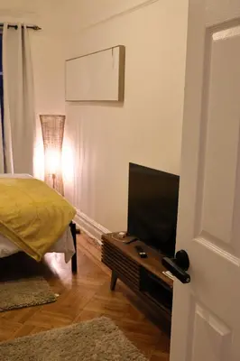 a bedroom with a bed and a table with a television at Santa Cruz rooms and hospitality