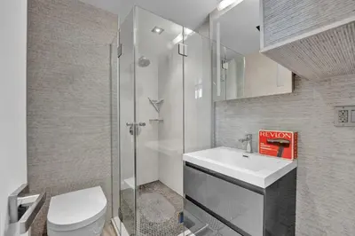 a bathroom with a toilet and a sink and a shower at SoHo Designer 2BR with balcony in New York