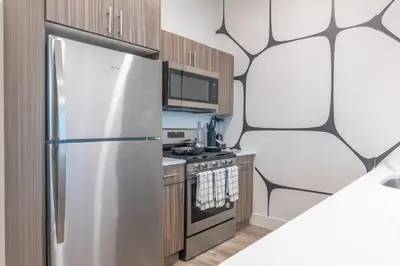 a kitchen with a stainless steel refrigerator at Luxury Lookout with NYC view, 2BR plus Free Parking, Sleeps 8, 20 Percent Off in East Orange