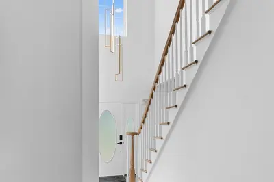 a stairway in a building with white walls and wooden stairs at Malkita Terra -Earthly Elegance in Woodbury