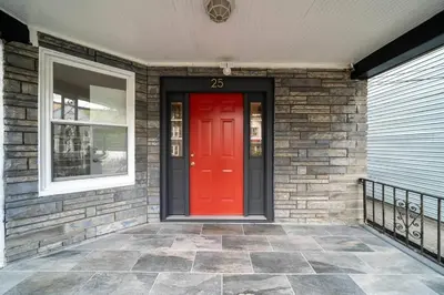 a red door on a brick house with a window at Spacious duplex retreat in city w/ Parking nearby in Jersey City
