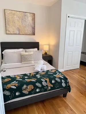 a bedroom with a bed with a green and white blanket at Sunset Slopes in Jersey City