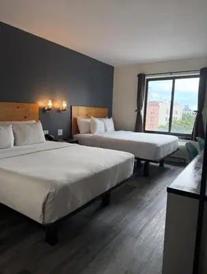 a hotel room with two beds and a window at Bklyn House Hotel New York Brooklyn in Brooklyn