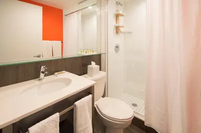 a bathroom with a sink and a toilet and a shower at Bklyn House Hotel New York Brooklyn in Brooklyn