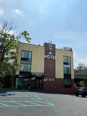 a hotel with a car parked in a parking lot at Nova Hotel Bronx in Melrose
